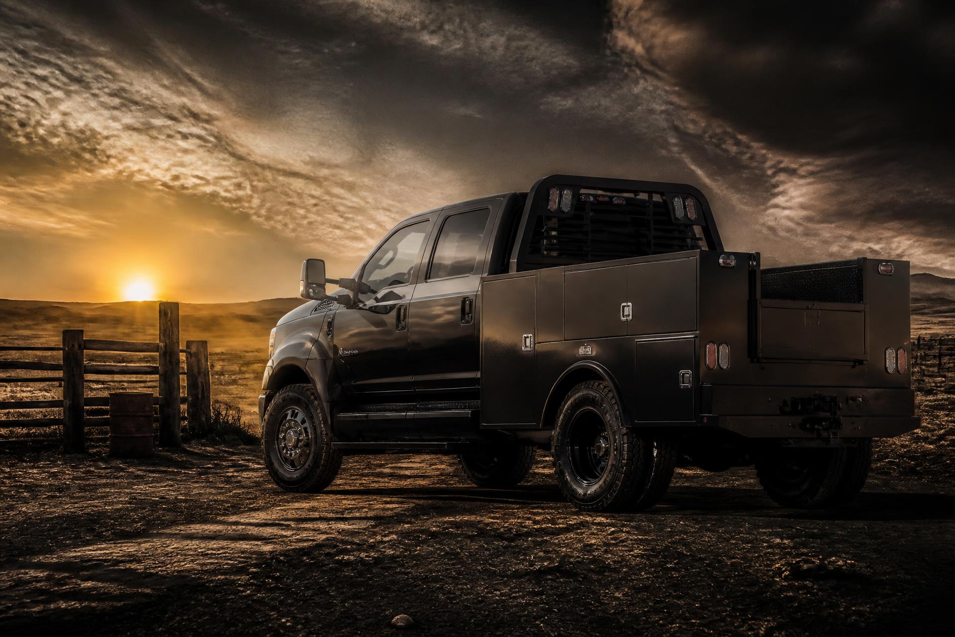 Black heavy-duty truck with a Patriot Bed Co service body at golden hour on American ranch land